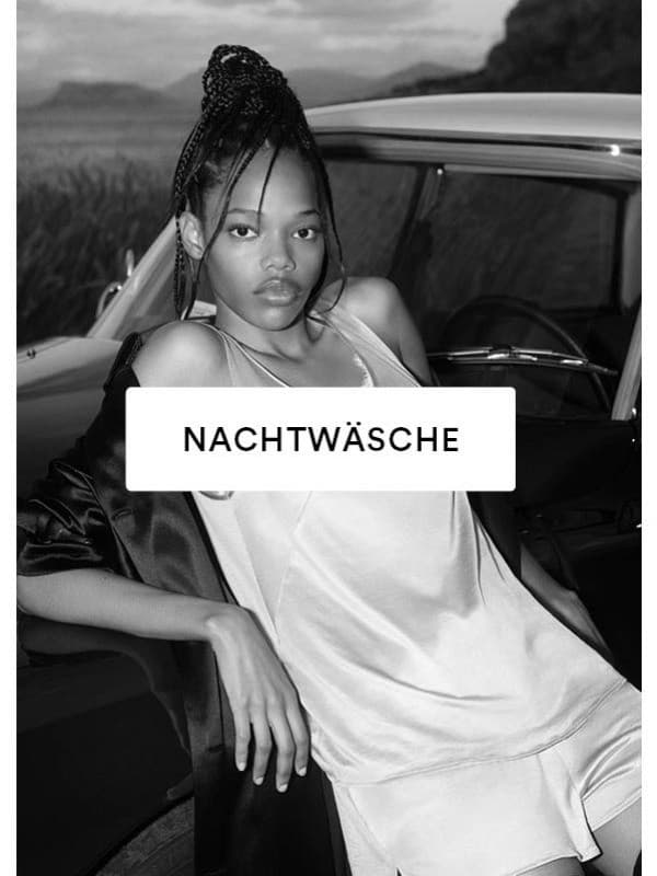 Schwarz/Weiß-Bild eines Models, das an ein Auto lehnt und ein Top mit passenden French Knickers trägt.